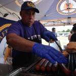 Clayton Franke / The Daily World
Phil Woltz, who runs the Aft Galley hot dog stand in Ocean Shores, places dogs on the grill on July 7.