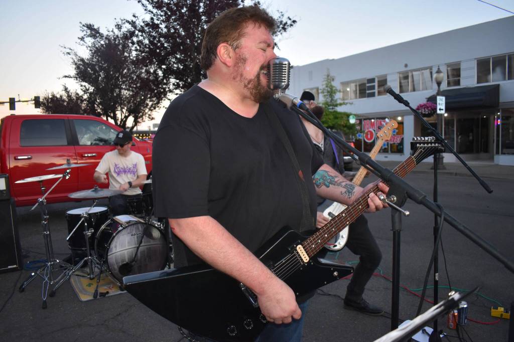 Matthew N. Wells / The Daily World
Phil Luce, center, on rhythm guitar and vocals, yells his heart out during Electric Eyes set Saturday at Aberdeen Founders Day Street Dance, in downtown Aberdeen. The band also features Luces nephews Dylan Blood  on drums  and Jake Blood, on bass, as well as Luces brother Dennis, who plays lead guitar.