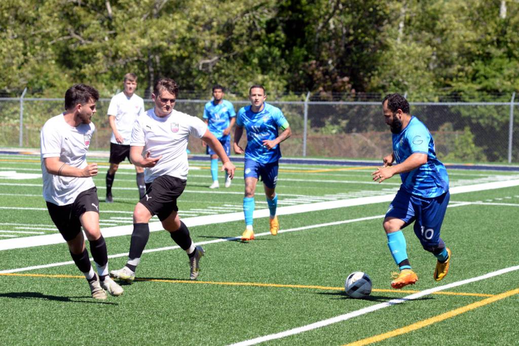 RYAN SPARKS | THE DAILY WORLD Grays Harbor Gulls forward Jonathan Molina, right, dribbles up the sideline against Steel United defenders during a 4-1 loss on Sunday in Aberdeen.