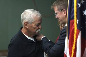 U.S. Rep. Derek Kilmer pins Marine veteran Bob Hamilton at the American Legion in Aberdeen. (Michael S. Lockett / The Daily World)