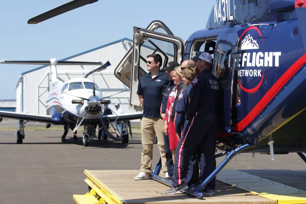 A Life Flight Network flight crew and local officials pose for a photo during the organizations grand opening ceremony at Bowerman Airport on July 26. (Michael S. Lockett / The Daily World)
