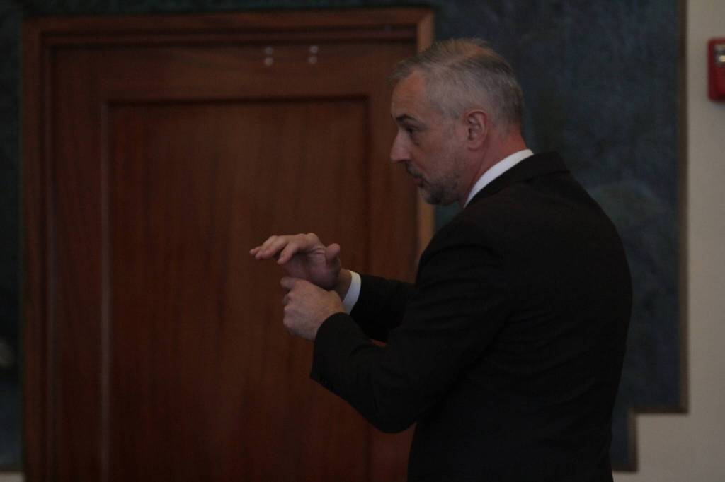 Jason Walker, leading the prosecution, simulates how the defendant may have held the revolver used in a shooting as he makes his closing statement on Aug. 18. (Michael S. Lockett / The Daily World)