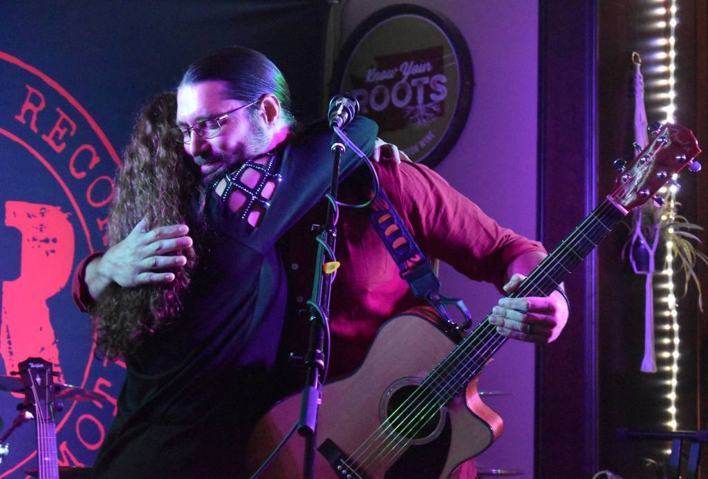 Matthew N. Wells / The Daily World
Alex Montoyas mom, Shauna Montoya, hugs Colin Gage, right, between songs in his set on Saturday night at the Songwriter Showcase Benefit for Alex Montoya. Gage was one of many musicians who played to the near-full bar and restaurant crowd. The benefit raised about $1,500.