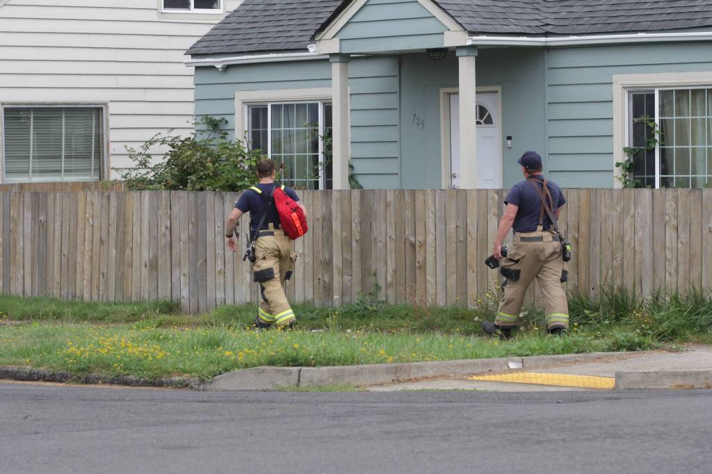 Michael S. Lockett / The Daily World
Hoquiam firefighters walk toward a house where a man was experiencing a mental health crisis on Aug. 28.