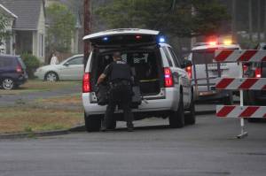 A sheriffs deputy pulls an equipment case out of a vehicle during a standoff in Hoquiam on Aug. 28. (Michael S. Lockett / The Daily World)