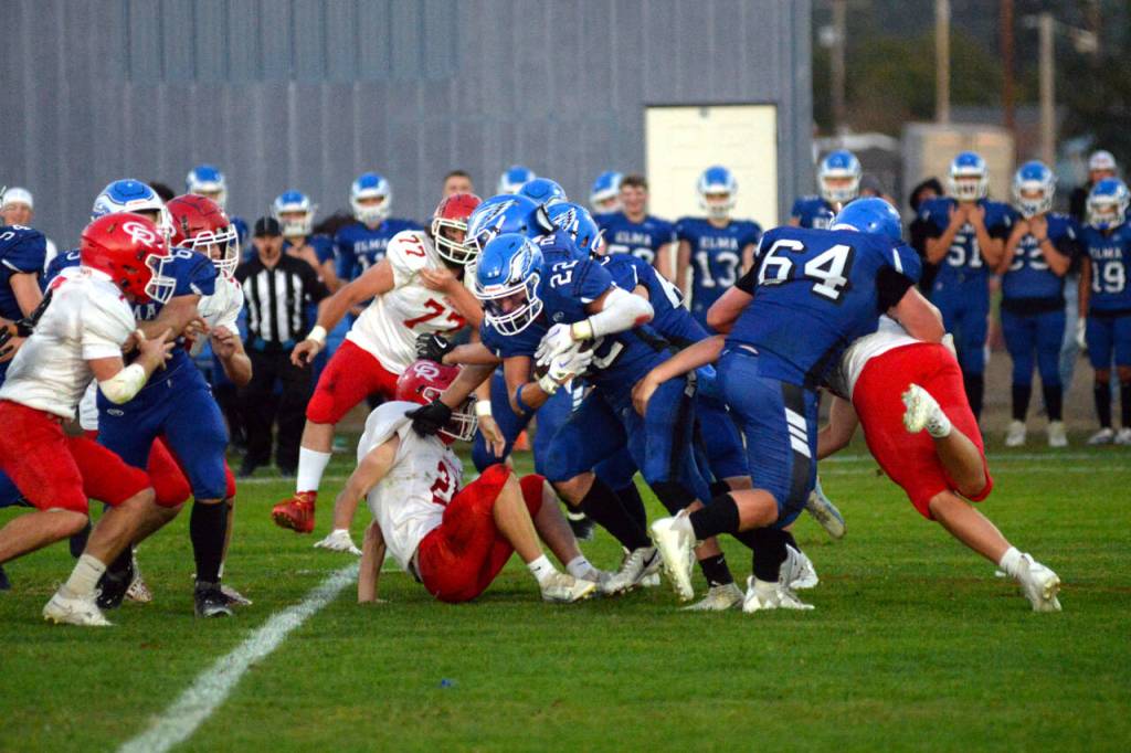 RYAN SPARKS | THE DAILY WORLD Elma running back Bo Muller (22) looks to squeeze through the Castle Rock defense during a 28-10 loss on Friday at Davis Field in Elma.