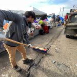 Matthew N. Wells / The Daily World
Oskar Campos, who works alongside Angel Baltazar to clean up Aberdeen and its ongoing trash problem, uses a push broom to form a pile so Baltazar can use a shovel and dump it into the city of Aberdeen truck they use. The pair works daily to pick up after Aberdeen. Much of their time is spent at the encampments underneath Chehalis River Bridge.