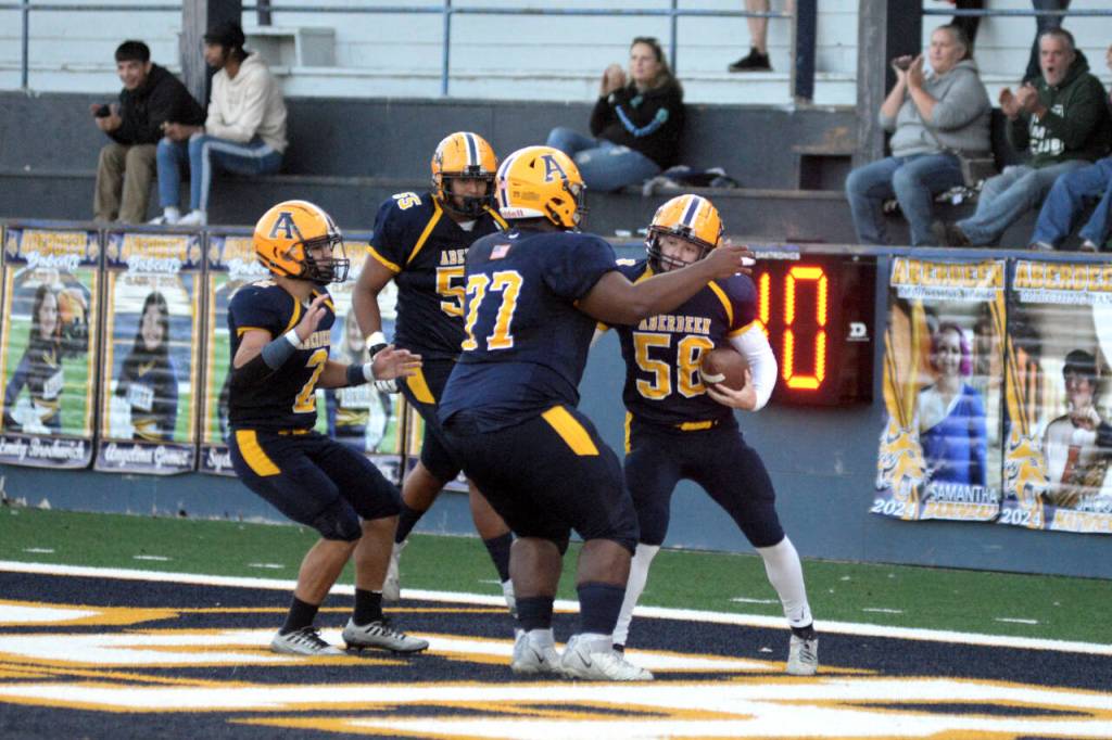 RYAN SPARKS | THE DAILY WORLD Aberdeen senior Nolan Cook (58) is surrounded by teammates Marcus Hale (2), Paul Baltazar (55) and JaBron Brooks (77) after scoring on a blocked punt during a 27-25 win over Prosser on Friday in Aberdeen.