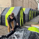 Matthew N. Wells / The Daily World
Rose Abbott, of Destination Hope and Recovery, assembles a small tent that will be used to house one or more homeless people. The city-provided tents, which multiple people say arent big enough, are lined in a staging area while city and state workers clean up the grounds where the State Street individuals actually live. One problem an engaged couple pointed out is their home they built and prepared for winter is now gone, so now theyll have to prepare for Grays Harbors rainy season, which started Saturday.