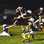 RYAN SPARKS | THE DAILY WORLD Raymond-South Bend quarterback Austin Snodgrass, top, is met by three Pe Ell-Willapa Valley defenders during a 14-12 loss on Friday at Crogstad Field in Menlo.