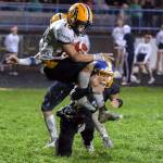 THE CHRONICLE Aberdeen running back Aidan Watkins, top, is tackled by Rochesters Ashtyn Diamond during a 20-8 win on Friday in Rochester.