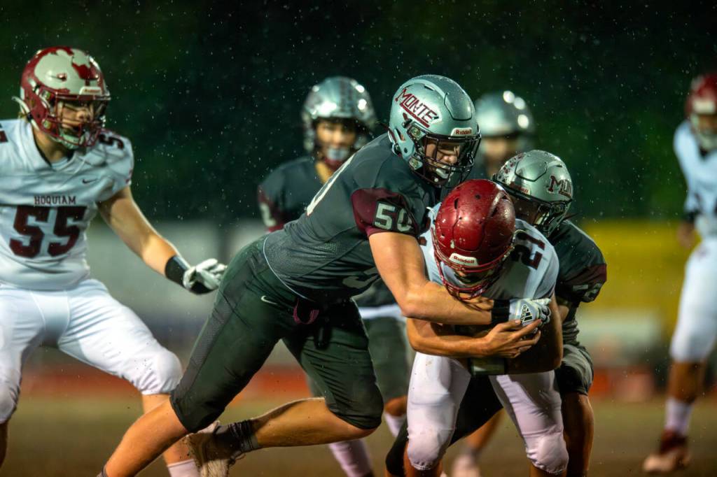 PHOTO BY FOREST WORGUM Montesano defenders Cam Taylor (50) and Peyton Damasiewicz (52) wrap up Hoquiam running back Dominic Standstipher during the Bulldogs 57-0 win on Friday at Jack Rottle Field in Montesano.