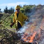 Clayton Franke / The Daily World
From left: Griffin Steele and Mathew Winter, Washington Conservation Corps crew members, work near a Scotch broom burn pile on Wednesday, Oct. 18. at the city of Ocean Shores public works yard.