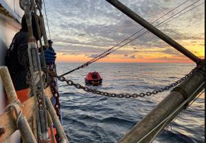 (U.S. Coast Guard Pacific Northwest) A good Samaritan vessel on Thursday, Oct. 26 approaches a life raft holding one of the two crew members from the missing fishing vessel Evening, found alive nearly two weeks after the boat was scheduled to return to Grays Harbor. The other crew member remains missing.