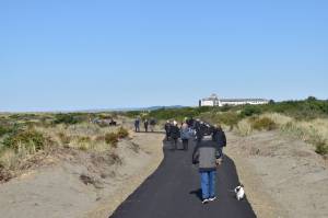 Walkers traverse the High Dune Trail on Saturday, Oct. 28. The new ADA-accessible trail in Ocean Shores affords wide views of the surrounding dune environment, the Pacific Ocean and nearby hotels. (Clayton Franke / The Daily World)