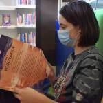 Naomi Watkins, a 21-year-old Hoquiam resident, has visited the library nearly every day for the past 10 years. She found her secondary home, when she was in fifth grade. Now, Watkins loves reading to her niece. Her niece loves dinosaurs, so it tickled Watkins to see Book of Dinosaurs  10 Record Breaking Prehistoric Animals. (Matthew N. Wells / The Daily World)