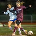 PHOTO BY FOREST WORGUM Montesano midfielder Sam Roundtree (9) and Bellevue Christians Lucy Carrel compete for possession in a 1A State Tournament first-round game on Wednesday in Montesano.