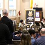 Marine veterans stand as Army bandmembers play their service anthem during a Veterans Day ceremony on Nov. 9. (Michael S. Lockett / The Daily World)