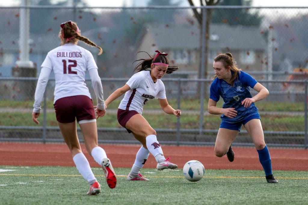 PHOTO BY FOREST WORGUM Montesano junior Adda Potts, middle, pressures La Center senior midfielder Shaela Bradley (5) during the Bulldogs 3-1 win in the 1A State third-place game on Saturday at Mount Tahoma Stadium in Tacoma.