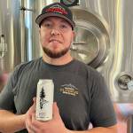 Michael S. Lockett / The Daily World
Head brewer and owner of Mount Olympus Brewery Orlando Maldonado poses with the beer they partnered with the Grays Harbor Conservation District on.