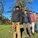 Grays Harbor Conservation Districts work crew poses behind a tree they recently planted, one of thousands, as part of a riverbank repair effort. (Michael S. Lockett / The Daily World)