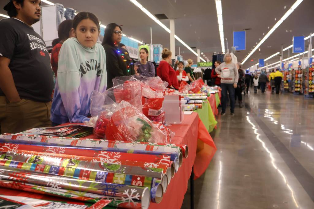 Michael S. Lockett / The Daily World
Volunteers wait to wrap presents during the annual Shop with a Cop event on Saturday.