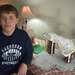 Matthew N. Wells / The Daily World
Fritz-Tyler Boyd, an Aberdeen eighth grader, kneels next to the space shuttle gingerbread house that he and his friend Tyler made. The shuttle won Winterfests Peoples Choice vote on Saturday.