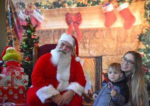 Matthew N. Wells / The Daily World
Santa Claus meets with Abram Veloni and his mom Taryn Veloni as The Grinch sits to the left of Ol Saint Nick. The Veloni family was impressed with Winterfest. I didnt know what to expect, but they have really blown us away, Taryn said.