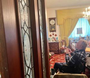 Clayton Franke / The Daily World
Charles Fattig, a McCleary history expert and member of the McCleary Historical Society, examines antique items in the home of longtime McCleary enthusiest John Anderson, who died in September at the age of 95. The wooden door with glass panels likely came from the Simpson Door Company factory, where Anderson worked for more than 40 years.