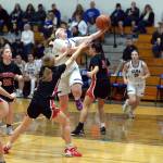 RYAN SPARKS | THE DAILY WORLD Elma senior point guard Emmie Spencer, middle, scores on a layup against Teninos Brianna Asay during the Eagles 49-21 win on Thursday in Elma.