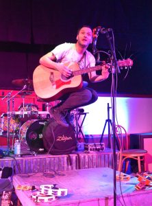 Matthew N. Wells / The Daily World
Greg Rekus, a long-time musician from Winnipeg, Canada, danced, stomped and jumped on the stage at The Loading Dock so much to the point he needed Gorilla tape applied to the tambourines so theyd not fall off while he performed. One of the ways Rekus described his energetic music was trashy acoustic, and the audience loved his style.