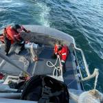 Coast Guardsmen get tow ropes ready.