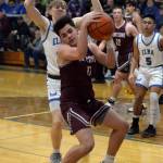 RYAN SPARKS | THE DAILY WORLD Montesano senior guard Jaxson Wilson, foreground, pulls down a rebound against Elmas Issac McGaffey during the Bulldogs 69-59 win on Friday in Elma.