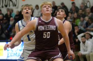 RYAN SPARKS | THE DAILY WORLD Montesanos Cam Taylor (50) Jaxson Wilson, right, compete for a rebound with Elmas Isaac McGaffey (1) during Montes 69-59 win on Friday in Elma.