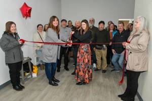 Kimberly Stoll-French / CCAP
Kimberly Stoll-French, center-right, and Cassie Lentz, center-left, cut a ribbon on Feb. 5 to signal to opening of a new 10-bed transitional housing project in Hoquiam that will host youth ages 18-24.
