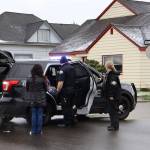 Suspects are detained for questioning following a police raid on a residence in Aberdeen on Thursday morning. (Michael S. Lockett / The Daily World)