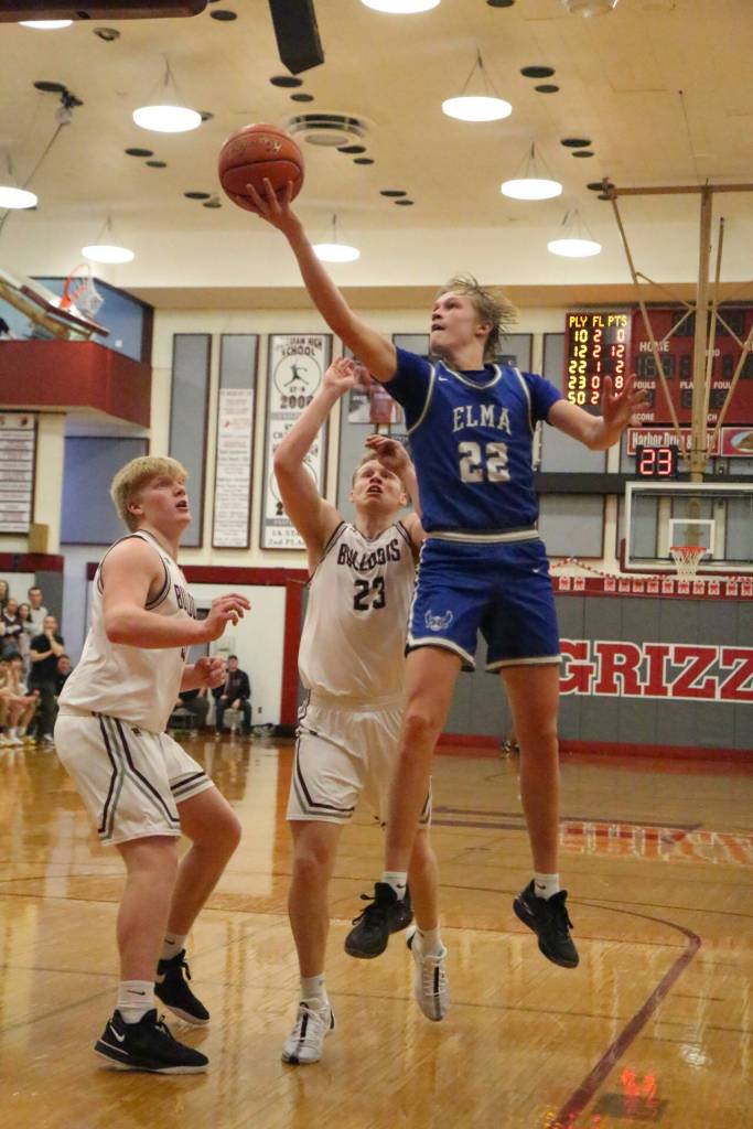 PHOTO BY FOREST WORGUM Elma senior guard Cason Seaberg (22) drives to the hoop against Montesanos Tyce Peterson (23) and Cam Taylor during the Bulldogs 63-54 win in the 1A District 4 third-place game on Saturday at Hoquiam High School.