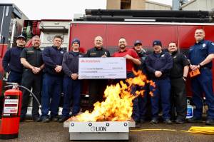 The Aberdeen Fire Department received a $10,000 grant from State Farm for a fire extinguisher training aid, on fire in the foreground. (Michael S. Lockett / The Daily World)