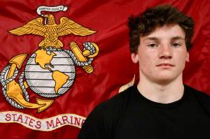 Dominik Jerome, left, stands before the Marine Corps flag during a send off before he departs for Marine Corps basic training. (Michael S. Lockett / The Daily World)