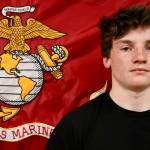 Dominik Jerome, left, stands before the Marine Corps flag during a send off before he departs for Marine Corps basic training. (Michael S. Lockett / The Daily World)