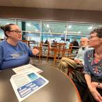 Matthew N. Wells / The Daily World
Nicole Evanson, senior director of aquatics and safety at the YMCA of Grays Harbor, explains many of the ways the YMCA helps children learn how to stay safe while near and in the water, as young students swim in the pool and their parents watch. Anne Foster, right, has endowed more than $1 million since 2011 so children can learn those safety tips. Her husband Will, center, whos proud of Anne, sits and listens.