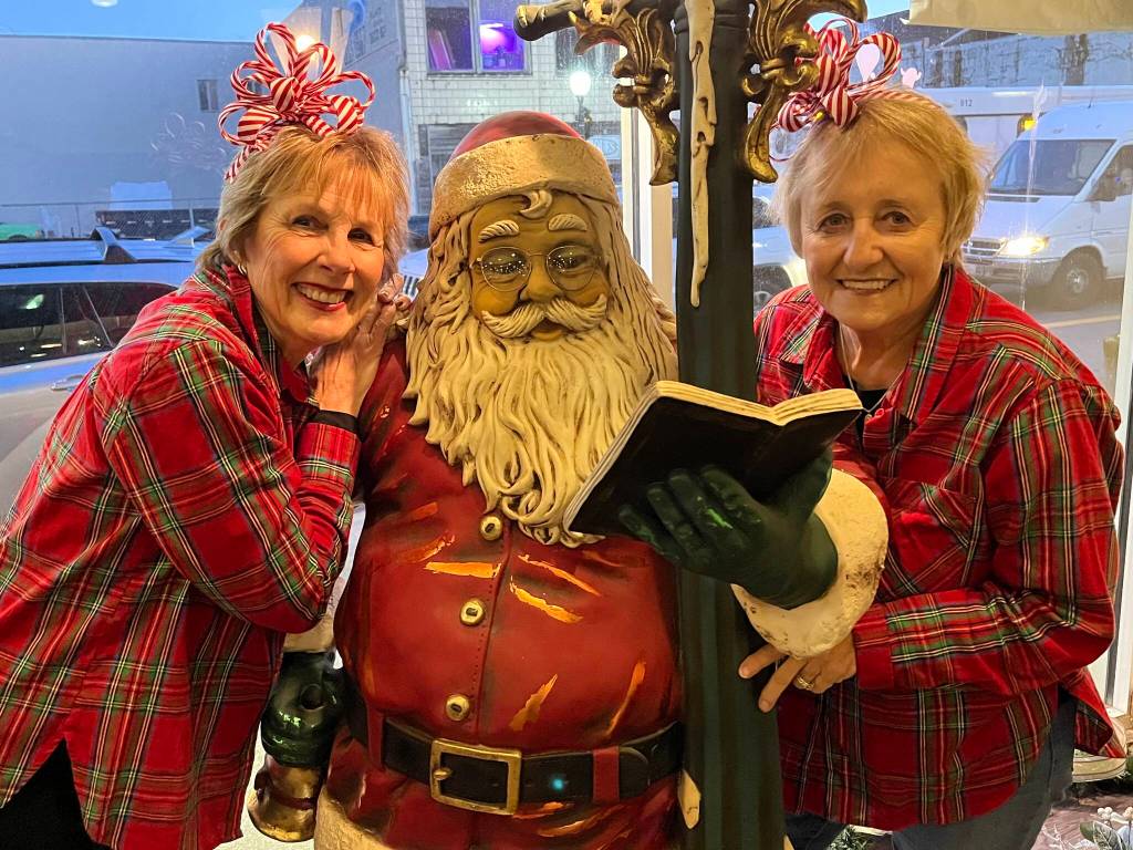 Bette Worth, left, and Bobbi McCracken, right, stand with a Santa Clause display to promote Aberdeen's Winterfest 2023. Worth and McCracken are two of the organizers for a community events forum that will be held on April 27 in order to help people interested in hosting their own community events with tips and guidance. The hope is more people, with even more learned lessons from their own events, will show up to make it even better. The deadline to sign up is April 17. (Matthew N. Wells / The Daily World)