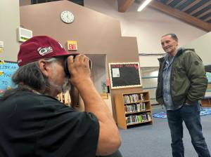 Clayton Franke / The Daily World
Ken Stevens, a Quinault tribal elder and former Taholah School Board member, peers into a virtual reality headset at the Taholah School Library on April 6 as Bill Adams, current school board member, looks on. As part of an open house to get ideas for the new planned Taholah school, the headset gave Stevens a virtual tour of the recently-constructed Toledo High School, which was designed by the same firm the district hired in Taholah.