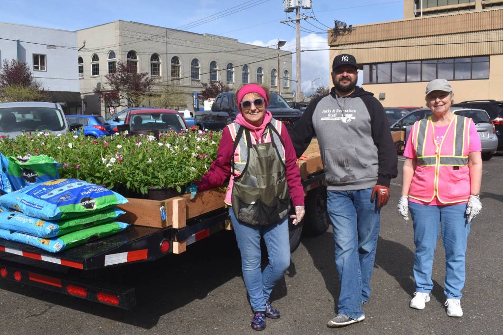 Bobbi McCracken, Craig Yakovich and Nancy LaCasse stand by the large trailer that pulled many of the plants Aberdeen Bloom Team placed throughout the city on Wednesday. Aberdeen Parks and Recreation Department staff joined the volunteers from Aberdeen Bloom Team to make sure the petunias, geraniums, million bells and bacopa plants were positioned in the flower pots just right. (Matthew N. Wells / The Daily World)
