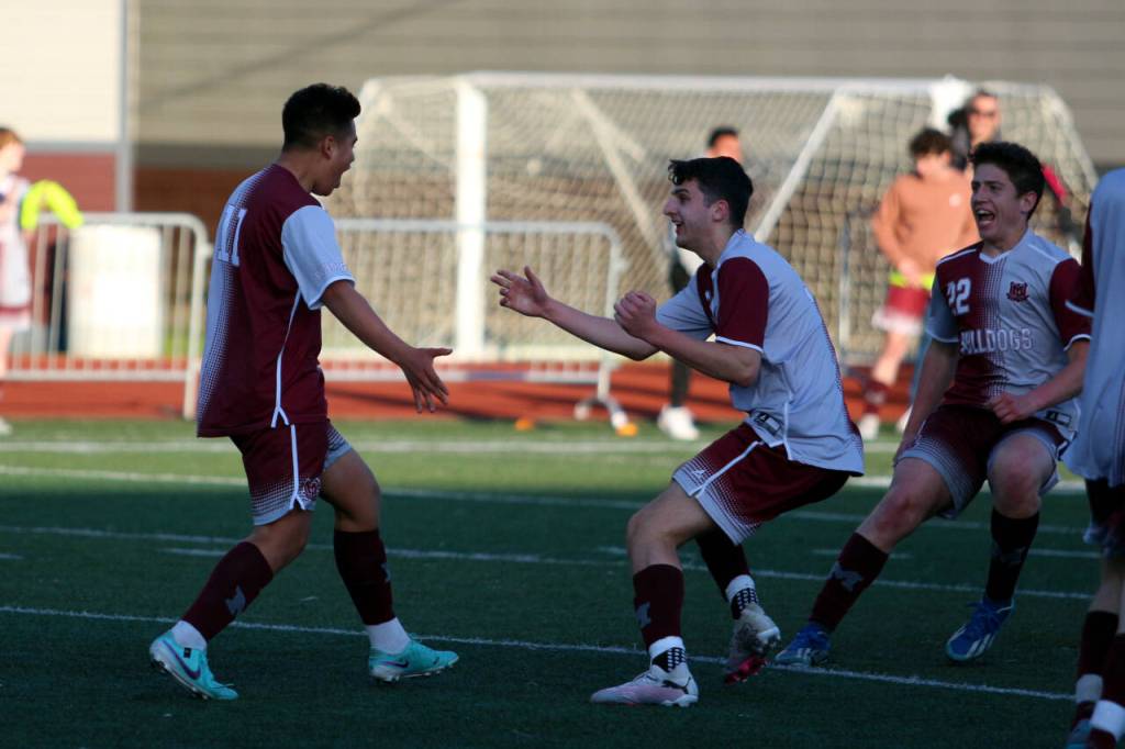 RYAN SPARKS | THE DAILY WORLD Montesano midfielder Andrew Melendez, left, celebrates with defenders Spencer Lovell and James Busche (22) after scoring a goal in the second half of a 3-2 win over La Center in the 1A District 4 Tournament on Tuesday in Montesano.