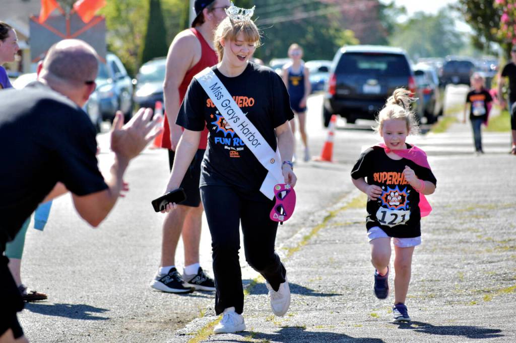 PHOTO BY RACHEL ROSE Miss Grays Harbor Joslyn Williams (left) encourages a young runner at the AJ West Fun Run on Friday in Aberdeen.