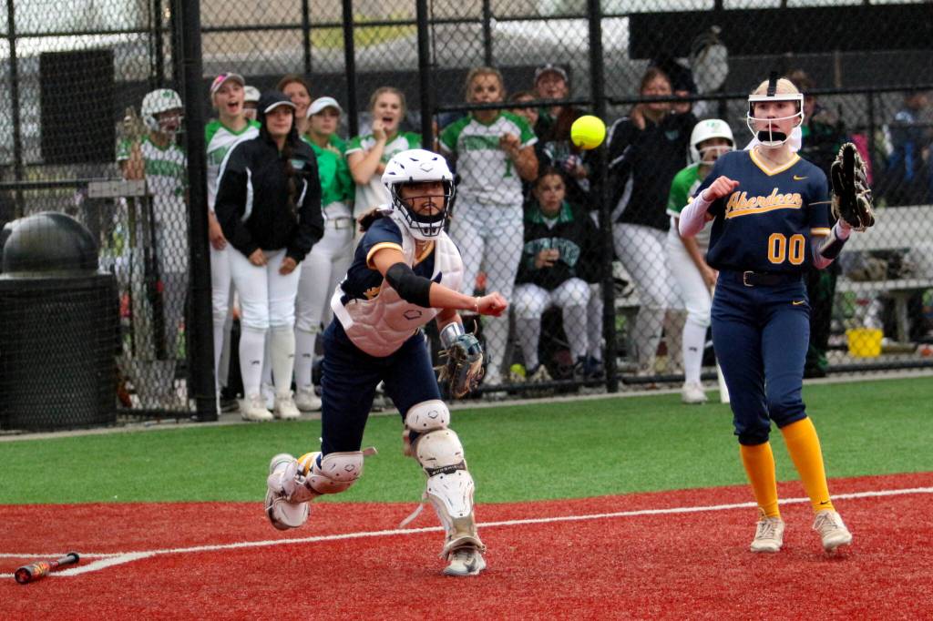 RYAN SPARKS | THE DAILY WORLD Aberdeen catcher Alyssa Yakovich (left) throws out a runner while third baseman Britten Neal looks on during the Bobcats 5-4 win over Tumwater in a 2A District 4 semifinal game on Thursday in Chehalis.