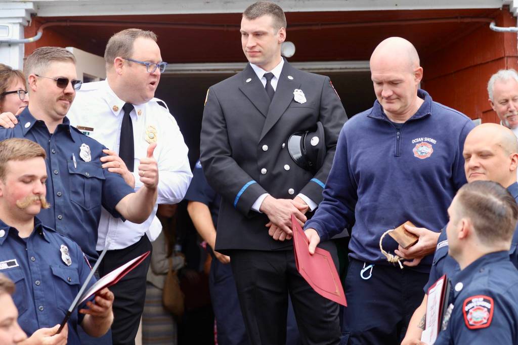 Volunteers from the Ocean Shores Fire Department graduating from the county fire academy pose for a photo with Fire Chief Brian Ritter, in white. (Michael S. Lockett / The Daily World)