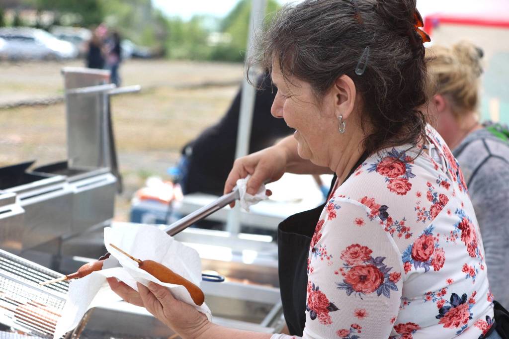 Capturing a woman smiling as she serves a corn dog to a hungry Splash Festival attendee. (Rick Moyer of Moyer Multi Media LLC.)