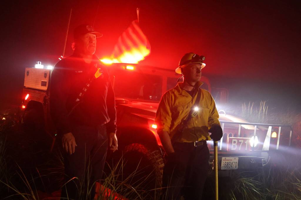 Michael S. Lockett / The Daily World
Ocean Shores firefighters respond to a dune grass fire on the 4th of July.